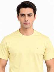 Light yellow T-shirt close-up showing crew neck and chest logo